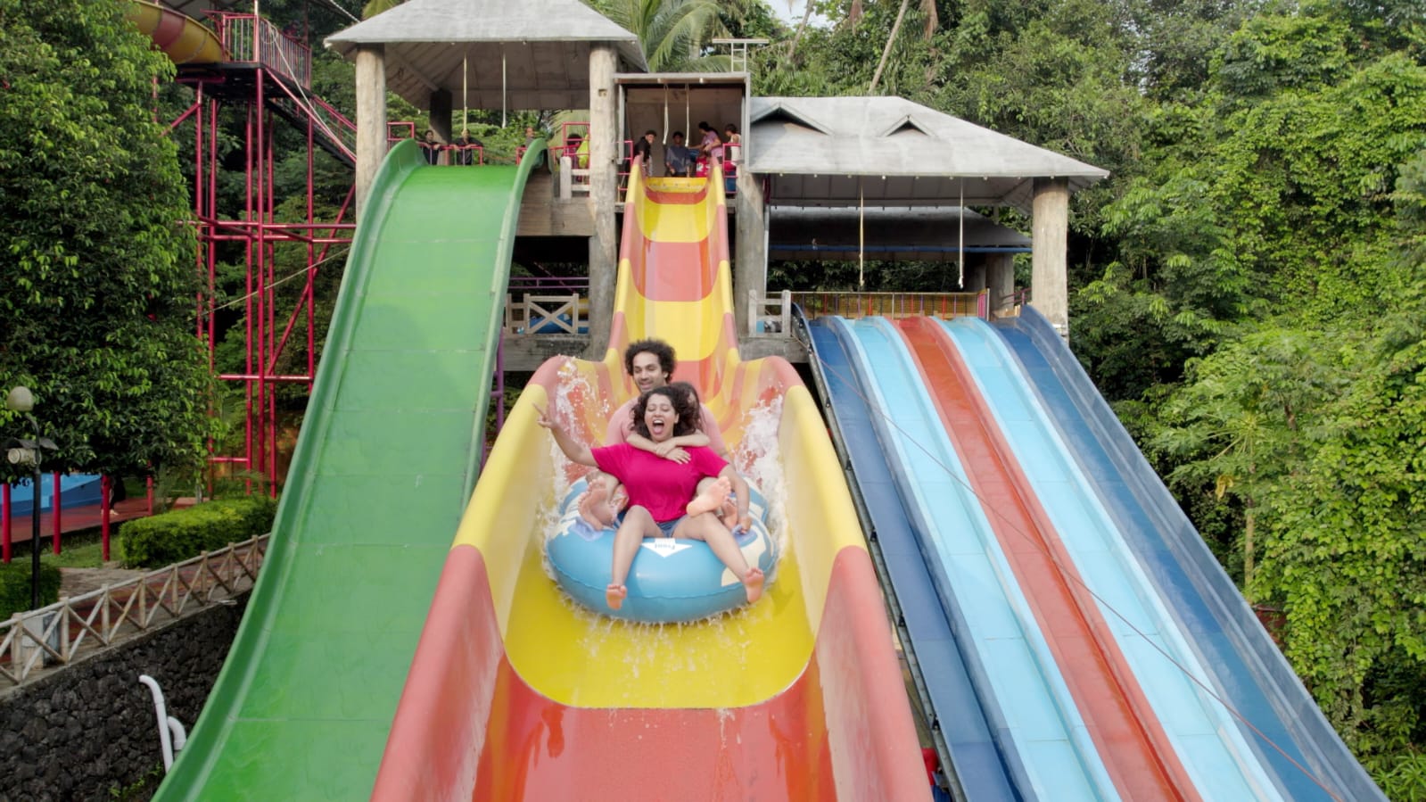 Family enjoying water slides at Flora Fantasia amusement park Kerala